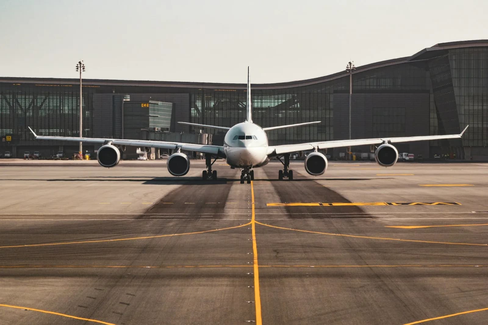 A wide-body passenger aircraft taxiing in front of a modern international airport terminal, where travellers arrive in Vietnam | BudgetBro