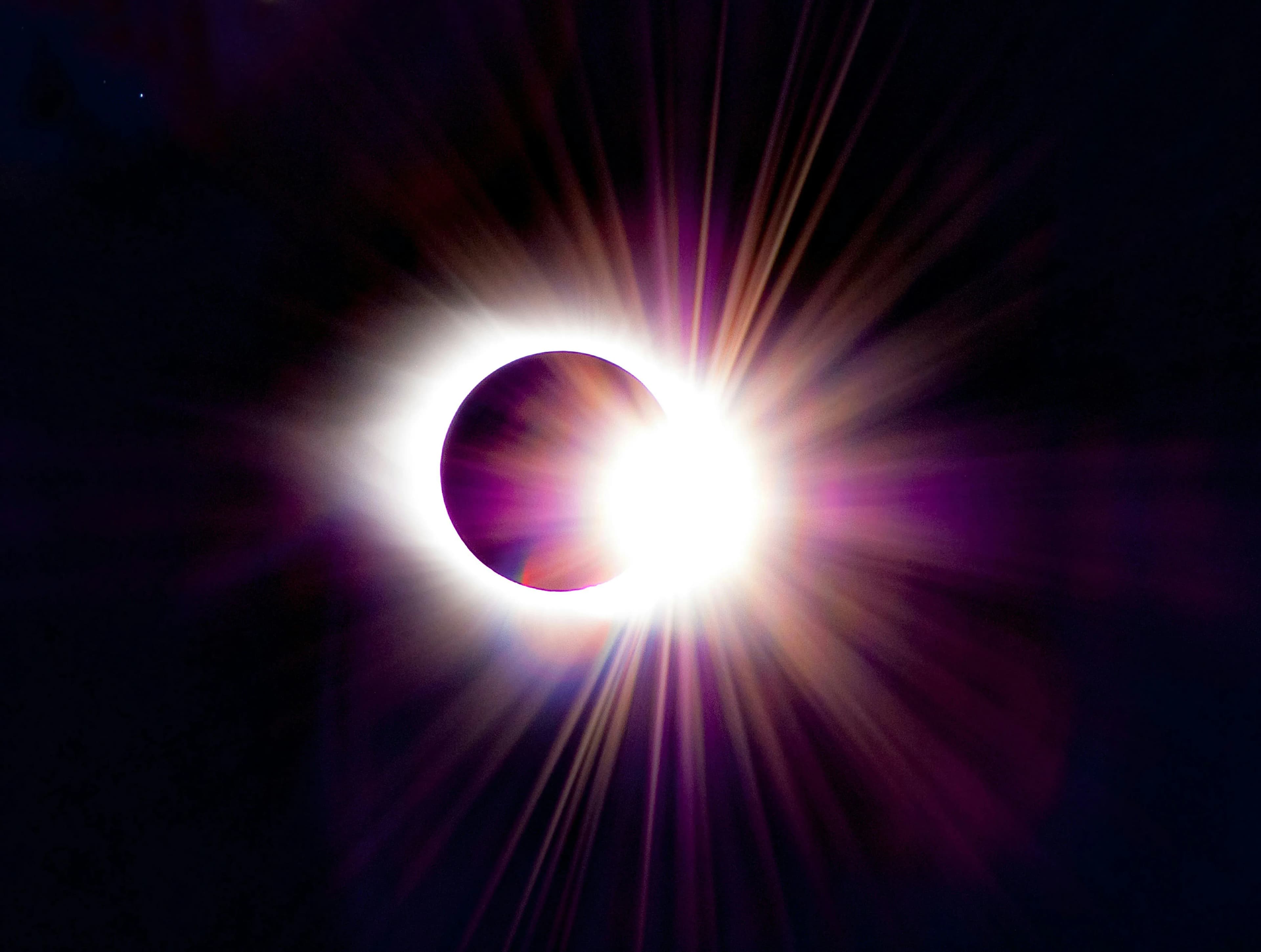 A total solar eclipse showing the sun's corona around the darkened moon | BudgetBro