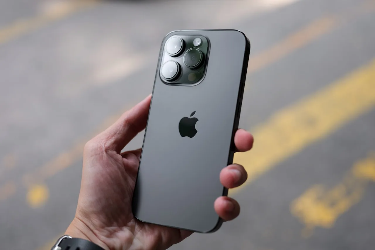 A recent iPhone Pro held in one hand, the type of device that runs iOS 27 and the new Siri in Camera bill-splitting feature | BudgetBro