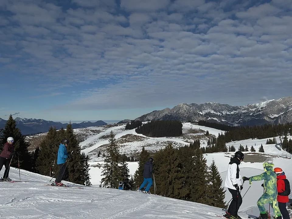 Skiers on a snowy slope in the Austrian Alps | BudgetBro