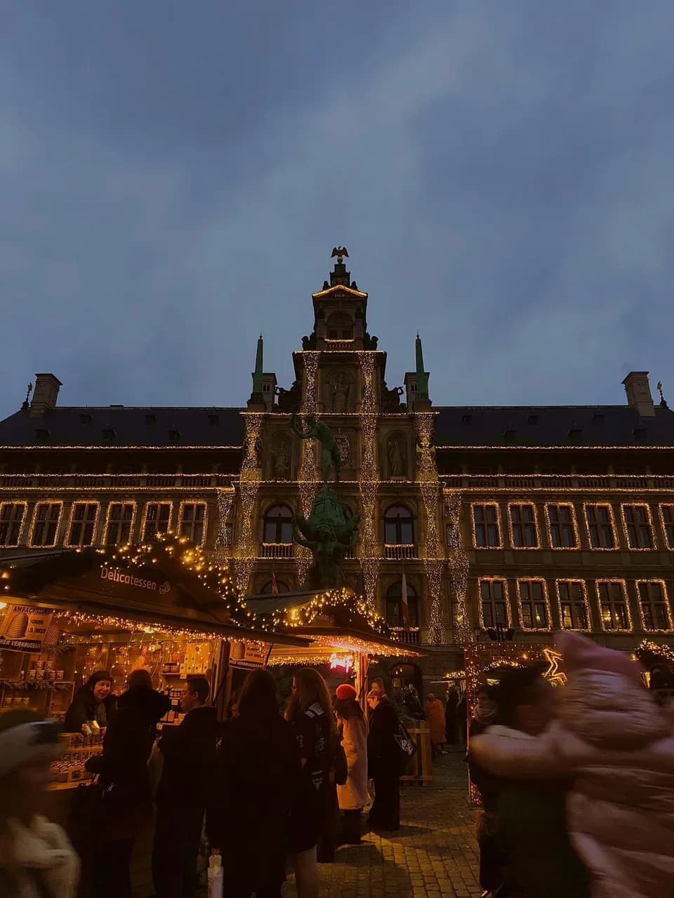Antwerp city hall lit up above the Christmas market stalls at dusk | BudgetBro