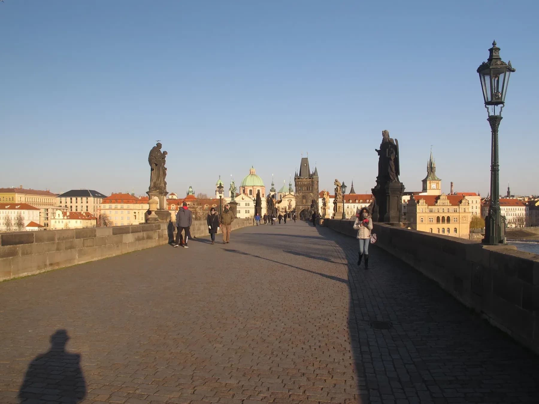Charles Bridge in Prague with its statues and lamps on a sunny day | BudgetBro