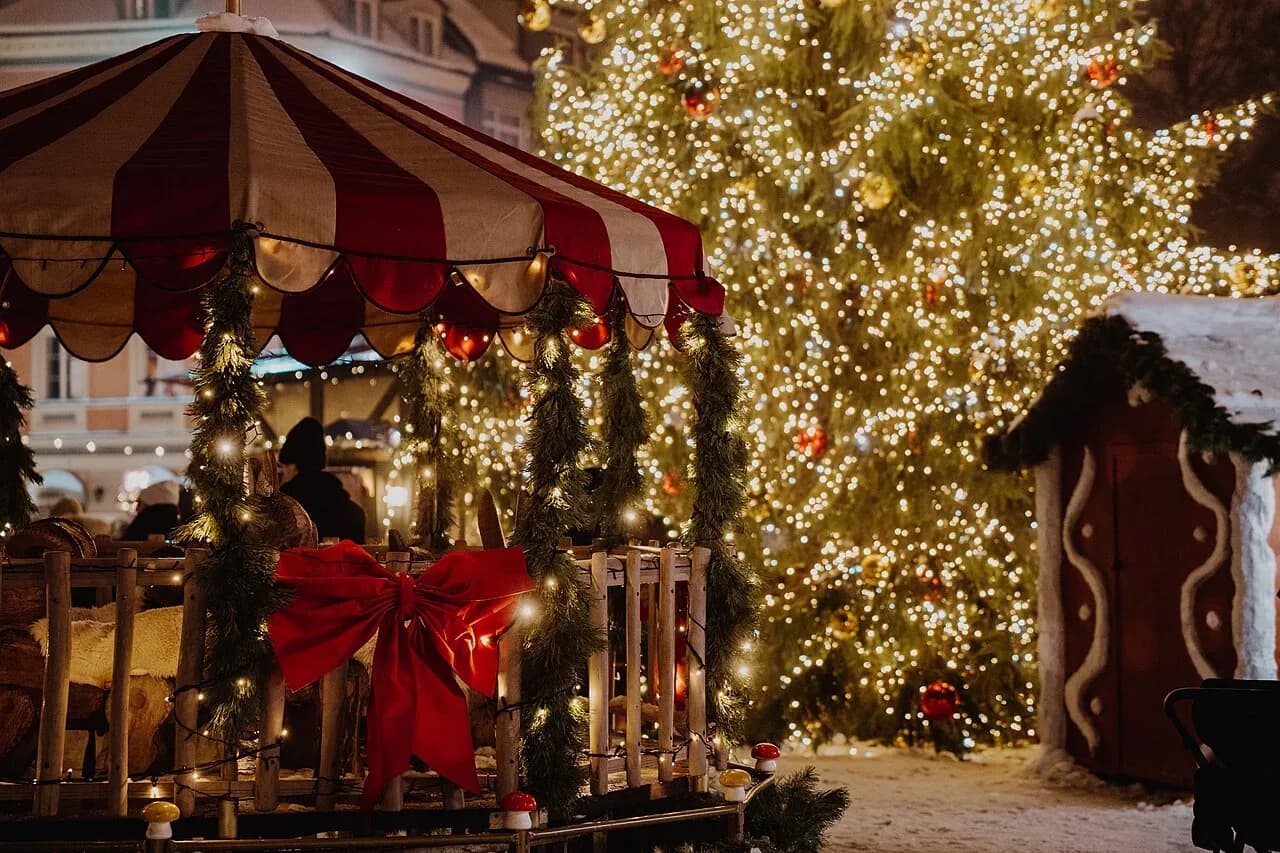 Christmas market stall and lit Christmas tree in Riga at night | BudgetBro