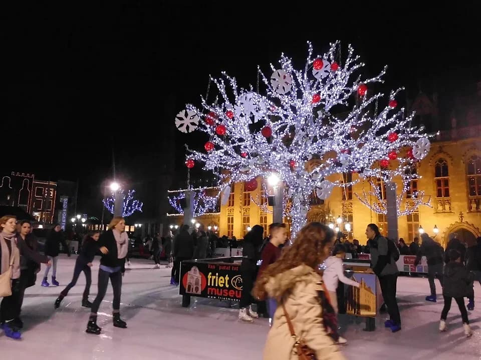 Ice skaters and a lit tree at the Christmas market on the Markt in Bruges | BudgetBro