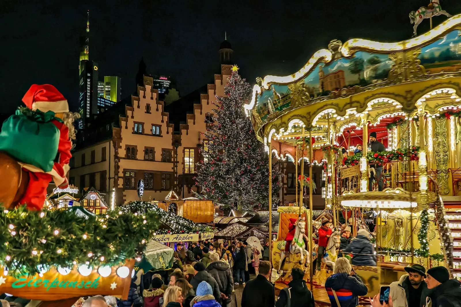 Lit-up carousel and Christmas tree at the Frankfurt Christmas market at night | BudgetBro