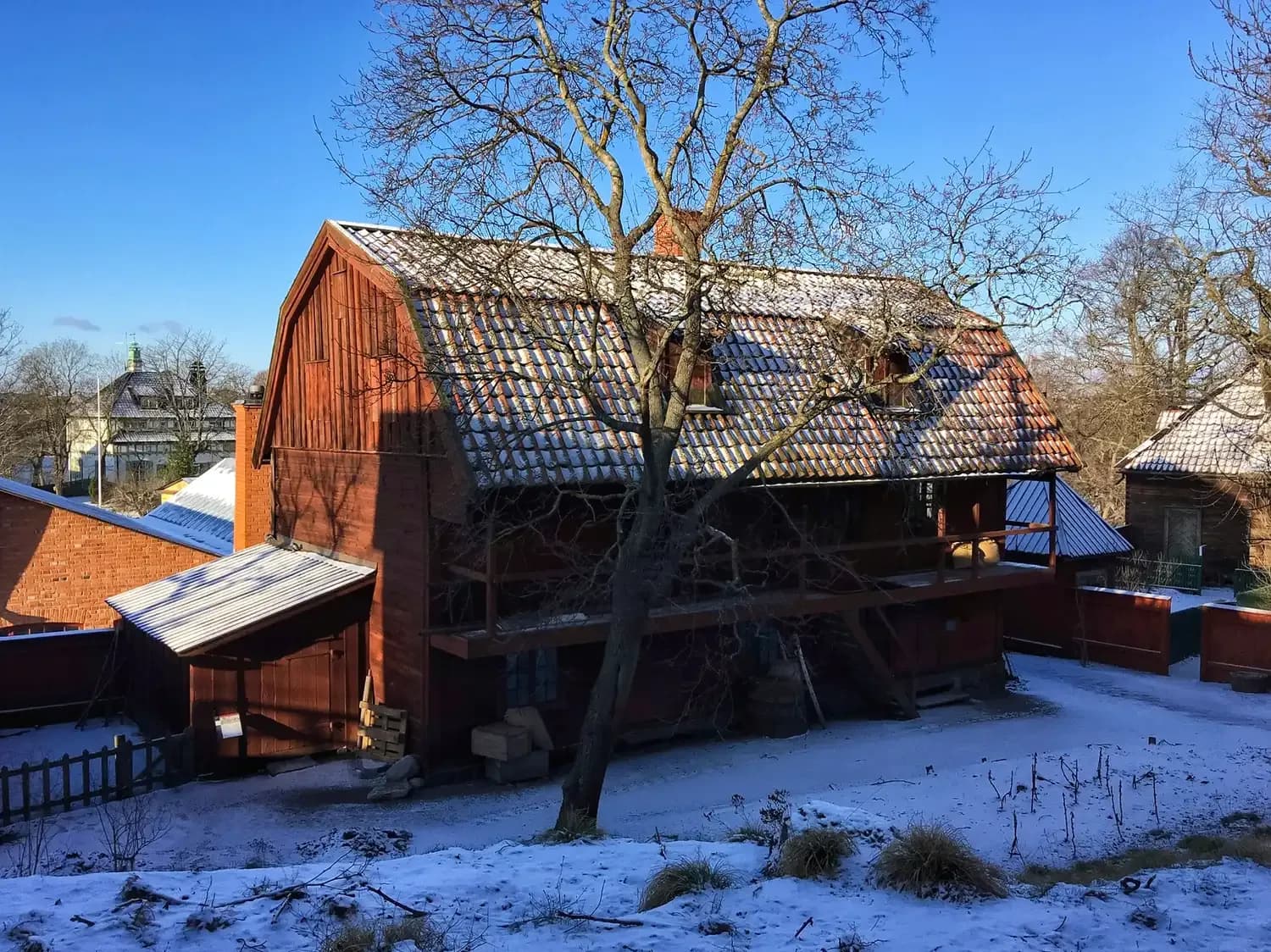Red wooden house at Skansen open-air museum in Stockholm with snow on the ground | BudgetBro