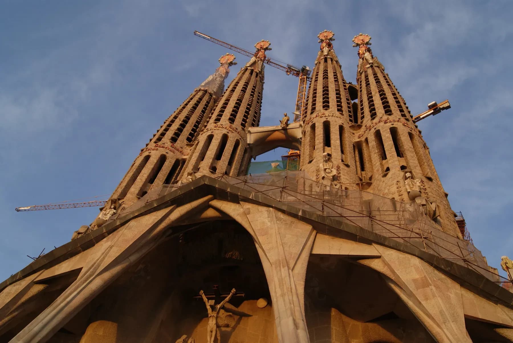 Sagrada Família towers in Barcelona against a blue sky, seen from below | BudgetBro