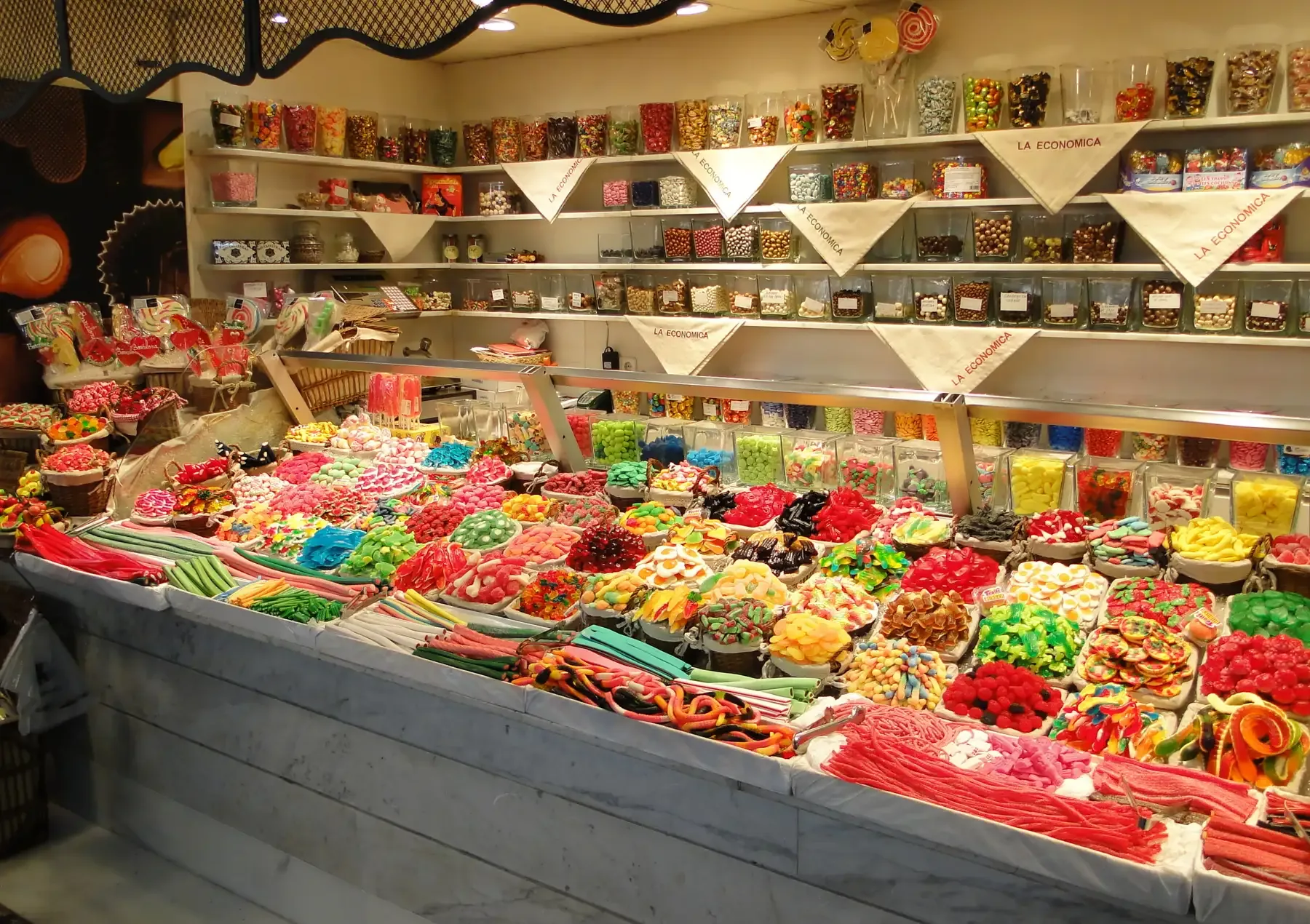 Sweet stall piled with colourful sweets inside La Boqueria market in Barcelona | BudgetBro