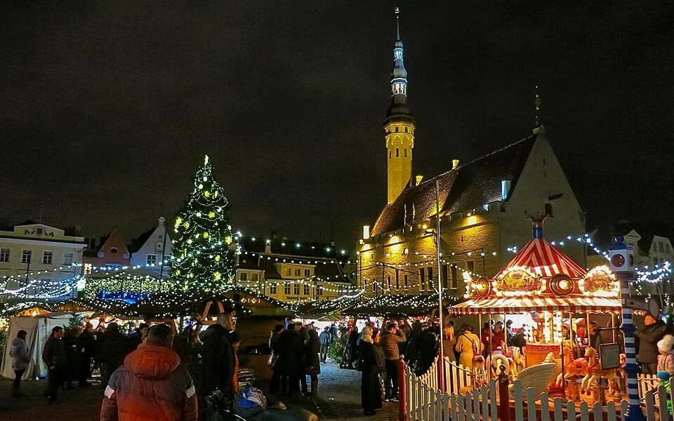 The Christmas tree and market stalls on Town Hall Square in Tallinn at night | BudgetBro