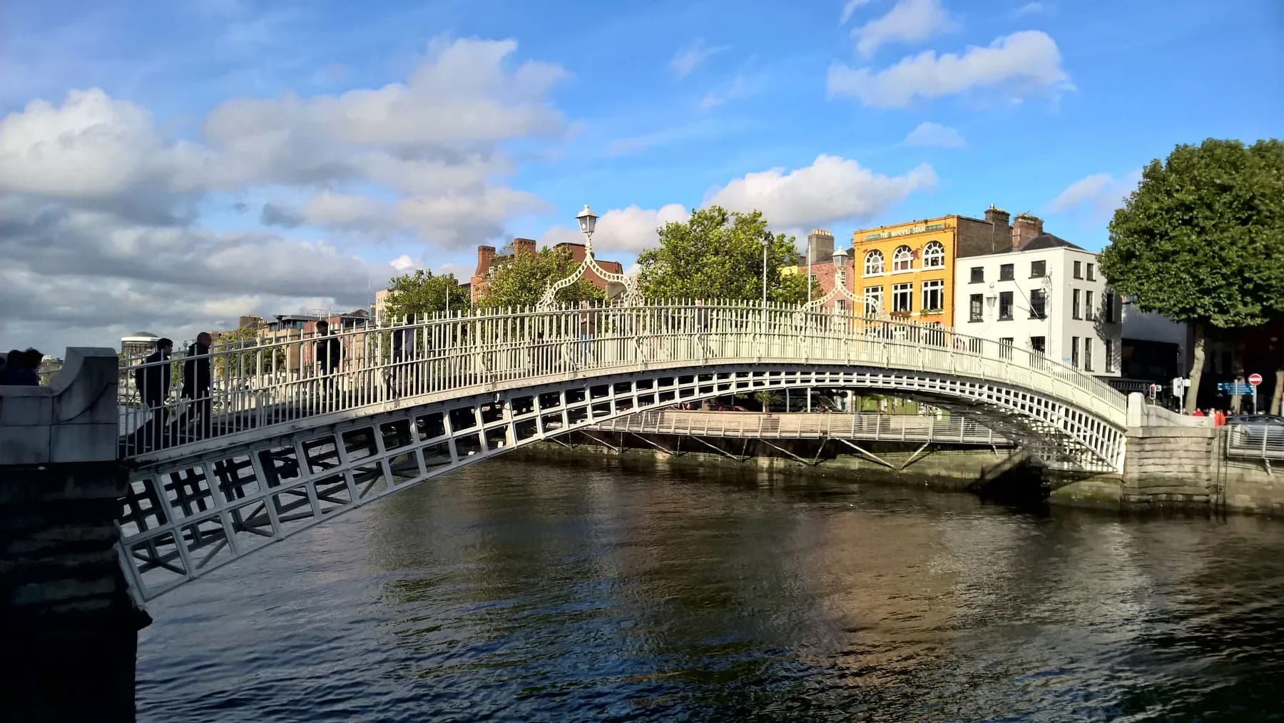 The Ha'penny Bridge over the River Liffey in Dublin on a sunny day | BudgetBro