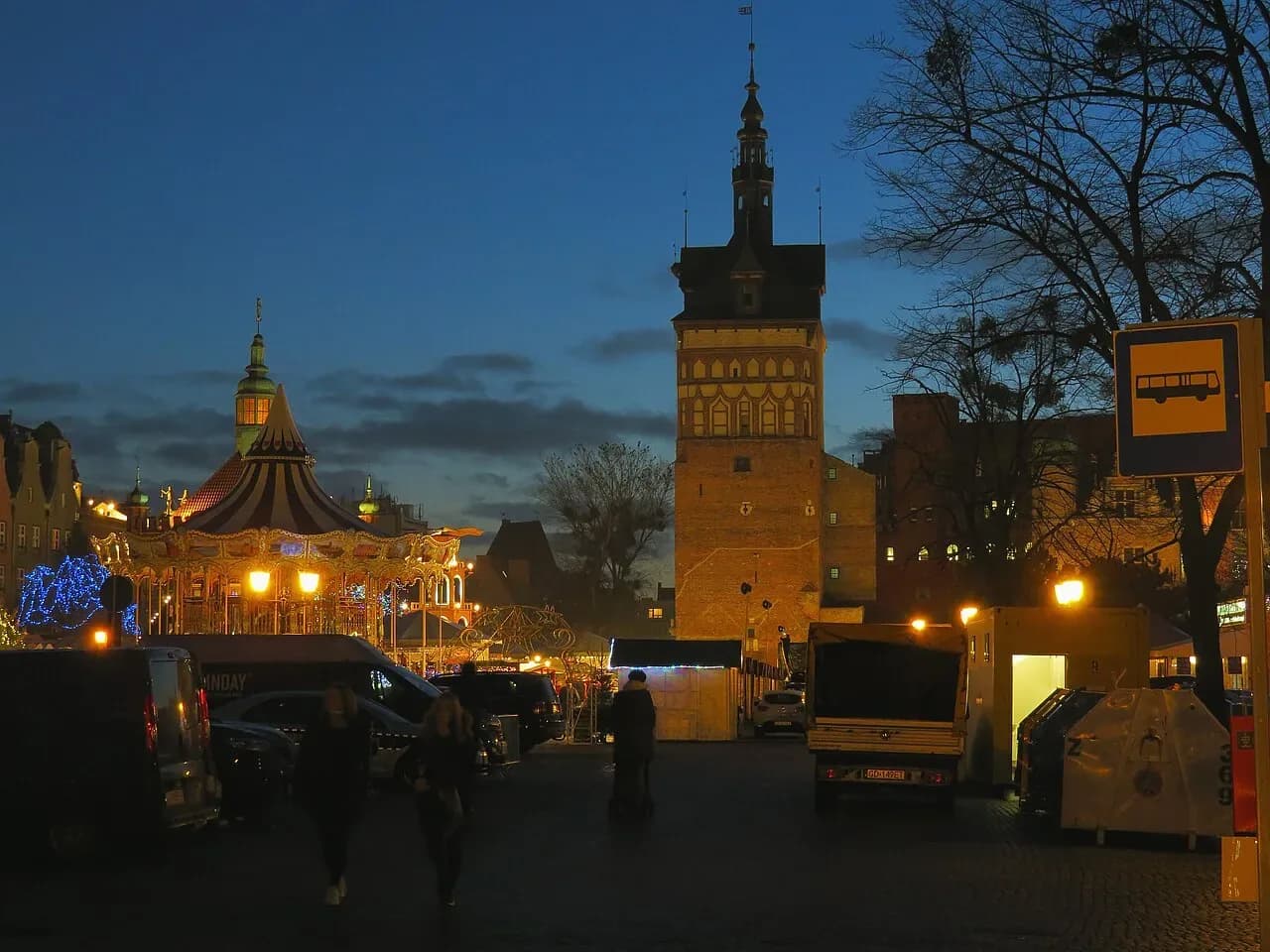 The Prison Tower and a lit carousel at the Gdańsk Christmas market at dusk | BudgetBro